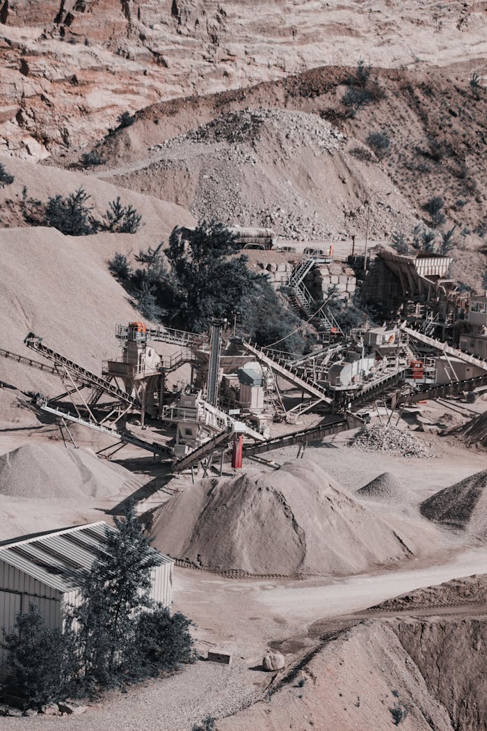 Aerial view of a large quarry with industrial machinery and equipment in operation.